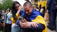 Egy ukrán katona beszél telefonon a rokonával, miután hazatért a fogságból 2025. május 24-én