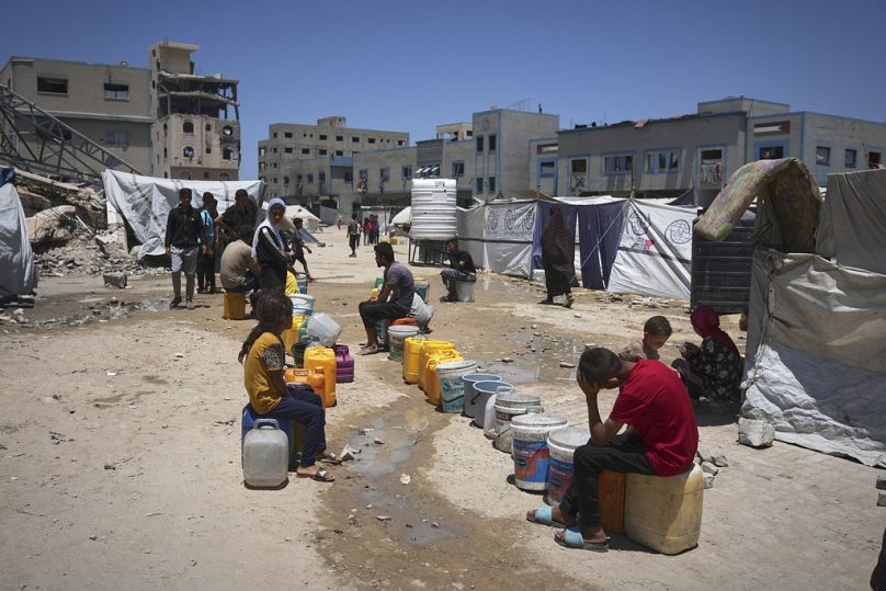 Crianças palestinianas esperam na fila para recolher água na Cidade de Gaza, sábado, 24 de maio de 2025.