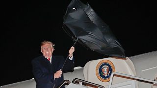 President Donald Trump having an issue with his umbrella while embarking on Air Force One President Donald Trump having an issue with his umbrella while embarking on Air Force One
