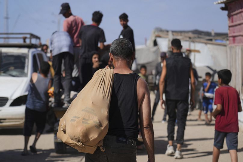 Decenas de palestinos llevan paquetes de alimentos y ayuda humanitaria entregados por la Fundación Humanitaria de Gaza, el 27 de mayo de 2025.