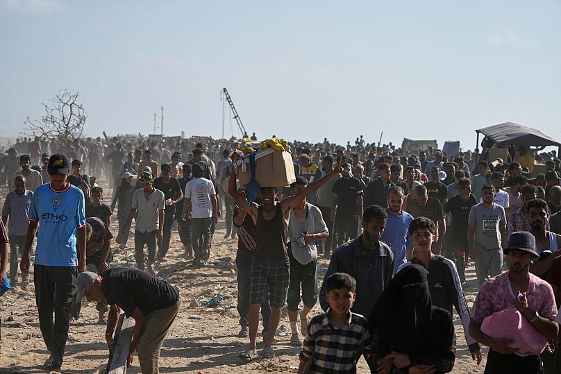 Des Palestiniens transportent des boîtes contenant de la nourriture et de l'aide humanitaire livrés par la GHF, à Rafah, dans le sud de la bande de Gaza, le mardi 27 mai 2025