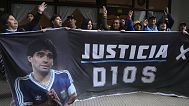 FILE: Fans of the late soccer star Diego Maradona hold a banner that reads in Spanish "Justice for God" outside the court in San Isidro, Argentina, March 11, 2025