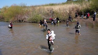 Syrian Alawite families cross a river marking the border between Syria and Lebanon in Akkar province, 11 March, 2025