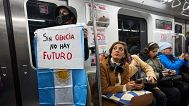 A woman holds a sign inside a subway car, in Buenos Aires, Argentina, Wednesday, May 28, 2025. 