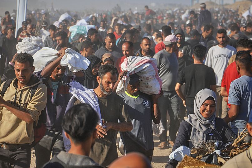 Palestinos transportan paquetes de ayuda humanitaria en Rafah, 29 de mayo de 2025