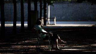  A man smokes a cigarette as he sits in the Tuileries Garden in Paris, 13 August 2016