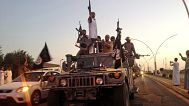Fighters from the so-called Islamic State group in a commandeered Iraqi security forces vehicle in the northern city of Mosul, 23 June, 2014