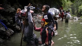 Haitian migrants wade through water as they cross the Darien Gap from Colombia to Panama in hopes of reaching the US, 9 May, 2023
