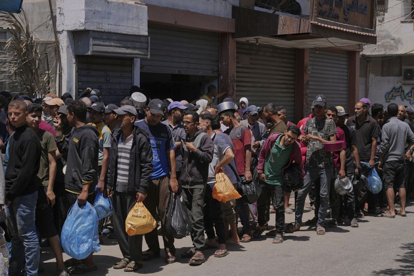 Des Palestiniens font la queue pour la distribution de nourriture à Deir al-Balah, Bande de Gaza, vendredi 30 mai 2025.