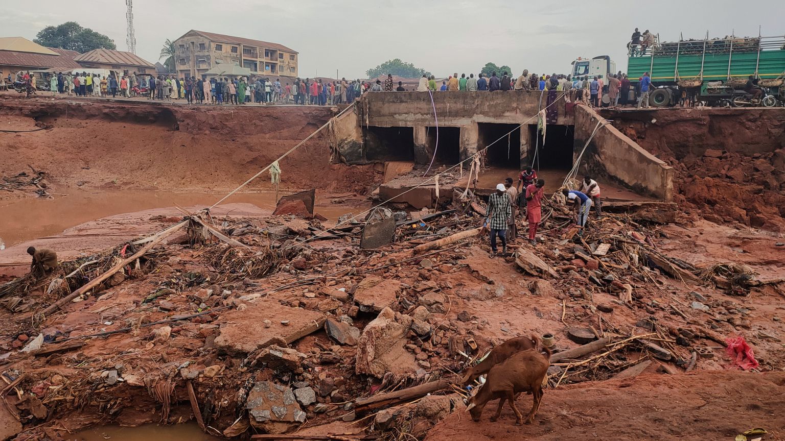 Des personnes cherchent dans une zone inondée suite à une pluie diluvienne à Mokwa, Nigeria, vendredi 30 mai 2025.