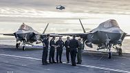 Britain's Prime Minister Keir Starmer, center left, and Defence Secretary John Healy, center right, talk with naval officers on the flight deck of HMS Prince of Walesin Plymou
