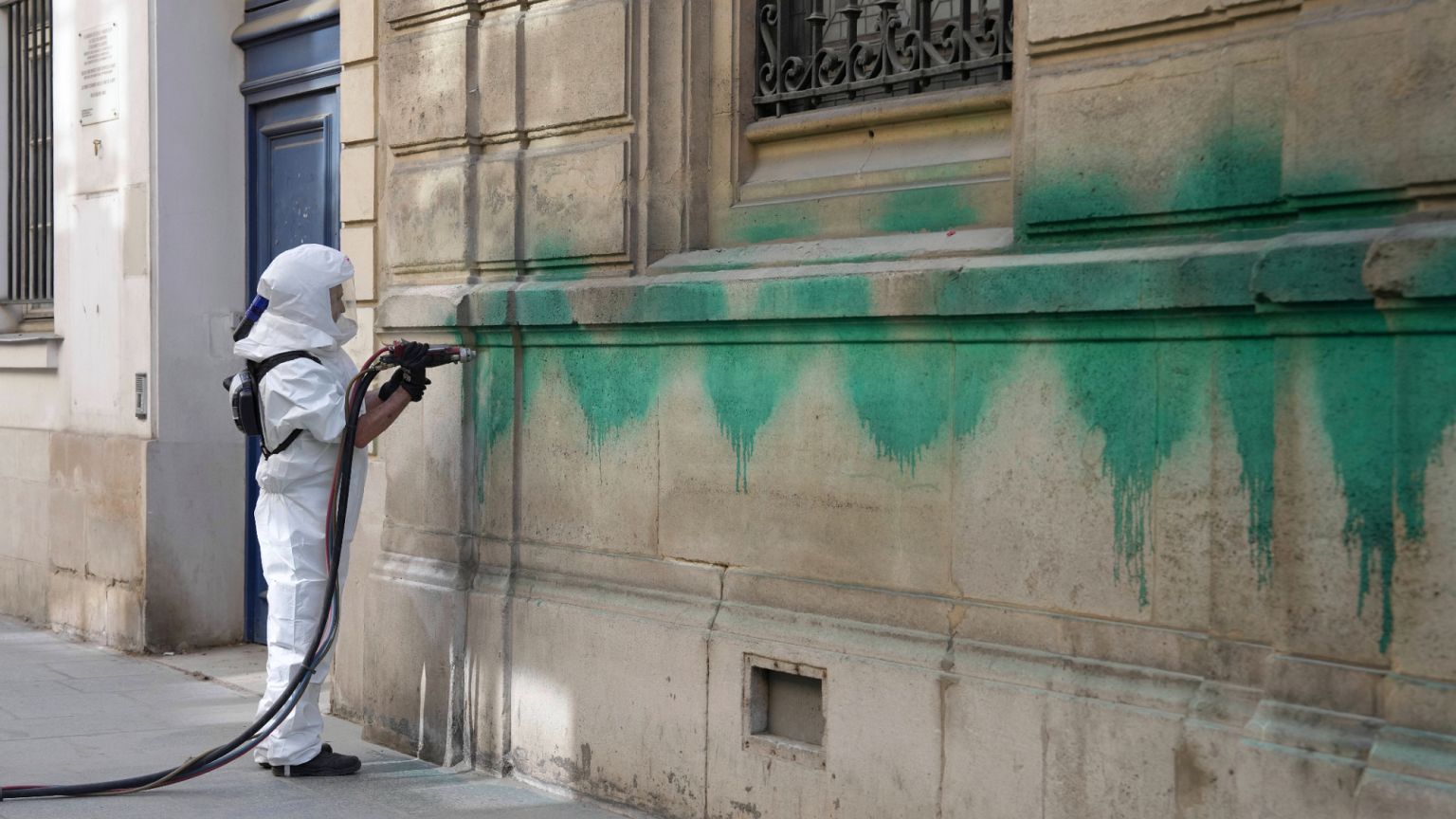 A worker cleans the defaced with green paint Synagogue des Tournelles after several Jewish sites across the capital were defaced with green paint, 31 May 2025
