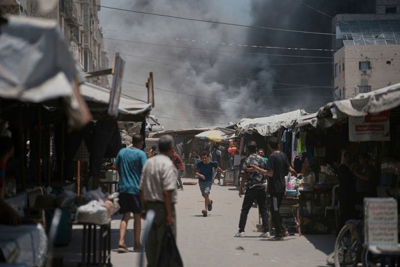 فلسطينيون يراقبون تصاعد الدخان بعد غارة إسرائيلية على مدينة غزة، الأحد 1 حزيران/يونيو 2025.