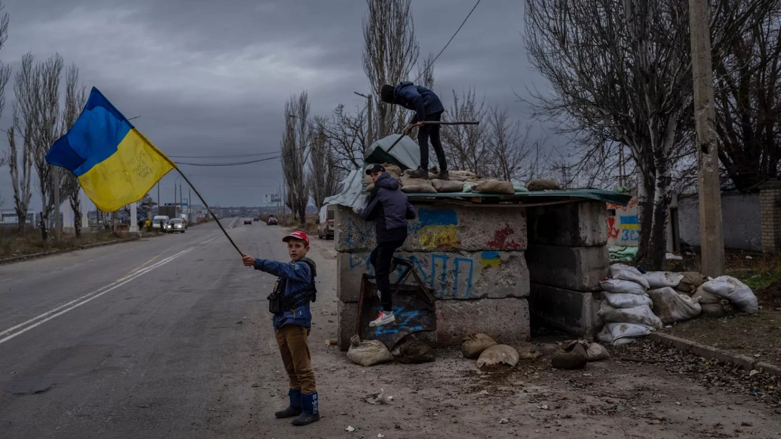 Ukrainian children play at an abandoned checkpoint in Kherson, southern Ukraine, Wednesday, Nov. 23, 2022.