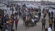 فلسطینیان کیسه های مملو از مواد غذایی و کمکهای بشردوستانه که توسط بنیاد بشردوستانه غزه، سازمانی مورد حمایت ایالات متحده و تأیید اسرائیل است، در خان یونس حمل می کنند.