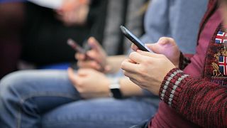 A young person uses their phone.