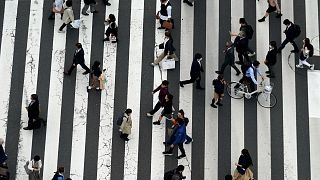 People walk along a shopping street on March 31, 2023, in Tokyo.