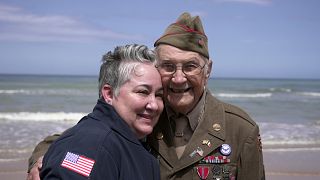 World War II veteran Wilbur Myers poses for a photo with a woman during a visit, June 2, 2025, to Omaha beach, which was one of the D-D-day invasion spots on June 6, 1944. 
