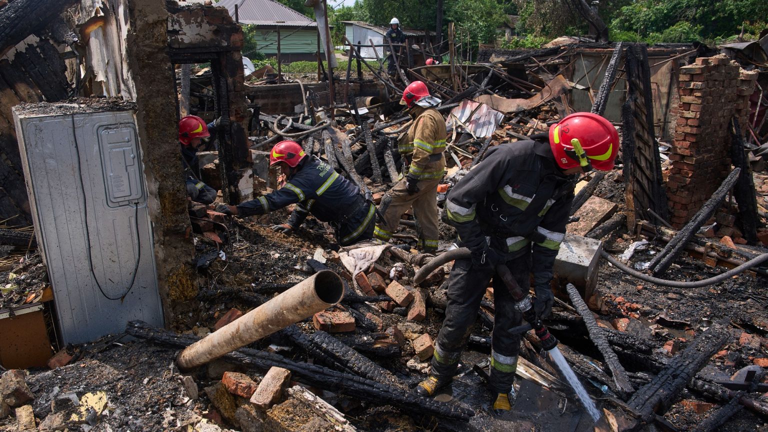 Rescue workers extinguish a fire of a house destroyed by a Russian drone strike in Pryluky, 5 June, 2025