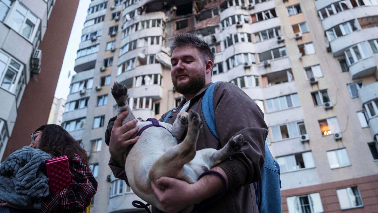 A man carries his dog in front of a residential multi-storey building damaged after a Russian drone strike on Kyiv, Ukraine, on Friday, June 6, 2025. 