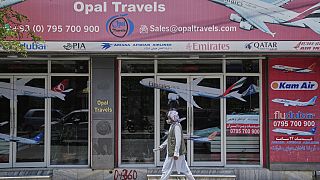 An Afghan person passes in front of an air travel agency in Kabul, Afghanistan.