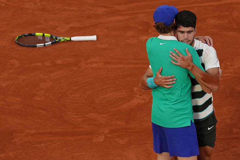 El español Carlos Alcaraz abraza al italiano Jannik Sinner tras ganar la final del Abierto de Francia en Roland-Garros, París, el domingo 8 de junio de 2025. 