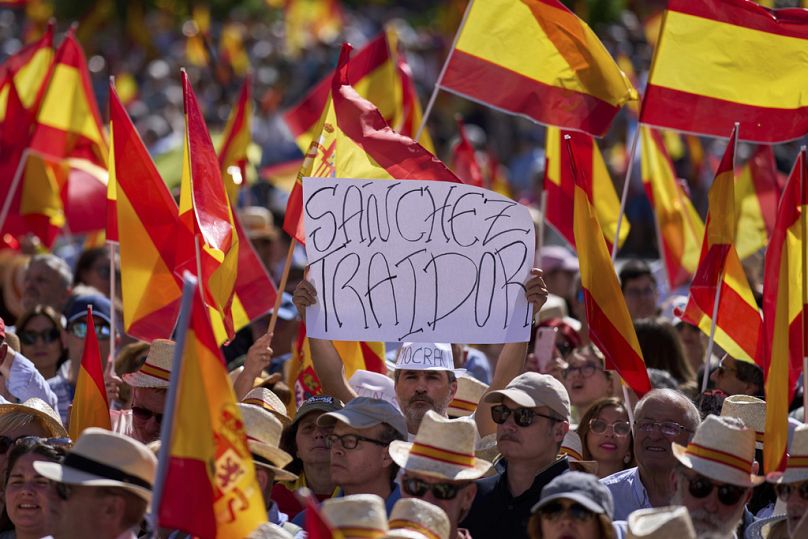 Un sostenitore del Partito Popolare, il principale partito conservatore spagnolo, tiene uno striscione con la scritta in spagnolo: “Sanchez traditore” durante la protesta