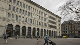 People walk past the facade of the Swiss National Bank, 