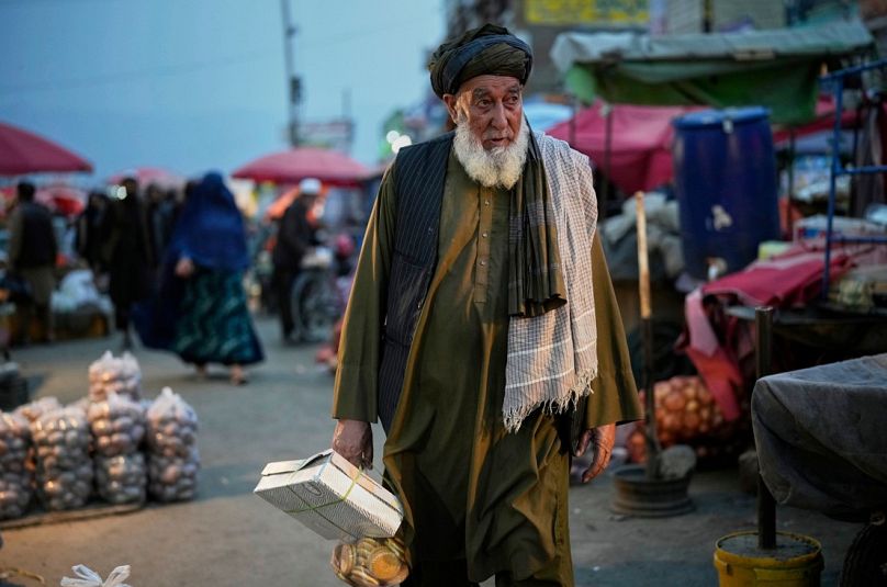 رجل أفغاني يتسوق في أحد الأسواق قبل يوم من عيد الأضحى المبارك في كابول، أفغانستان، الجمعة 6 يونيو/حزيران 2025.  