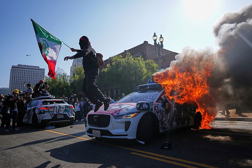 فردی با پرچم مکزیک در ناآرامی‌های لس‌آنجلس به تاریخ هشتم ژوئن ۲۰۲۵