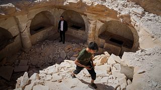 A boy emerges from a pit after exploring 1,500-year-old Byzantine tombs uncovered during reconstruction in war-damaged Maarat al-Numan, Idlib, Syria, on 30 May 2025.