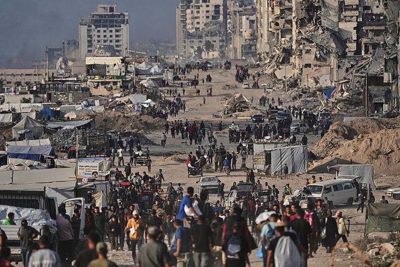 Palestinos desplazados caminan junto a las ruinas de edificios destruidos a lo largo de la costa de la ciudad de Gaza, 9 de junio de 2025.