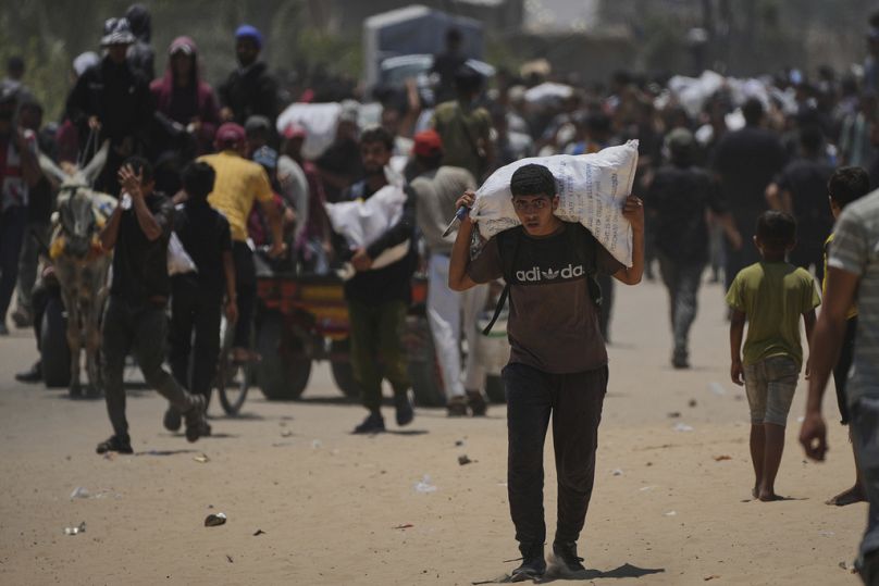 فلسطينيون يحملون مساعدات غذائية وإنسانية قدّمتها مؤسسة غزة الإنسانية المدعومة من الولايات المتحدة، في رفح جنوب قطاع غزة، الإثنين 9 حزيران/يونيو 2025.
