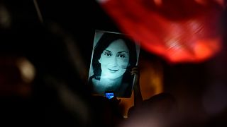 A protester holds a picture of murdered reporter Daphne Caruana Galizia during a demonstration outside the prime minister's office in Valletta, 27 November, 2019