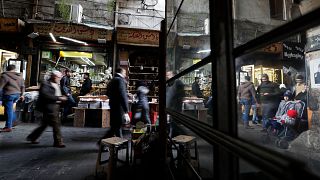 People walk through a market in Damascus, 15 December, 2022