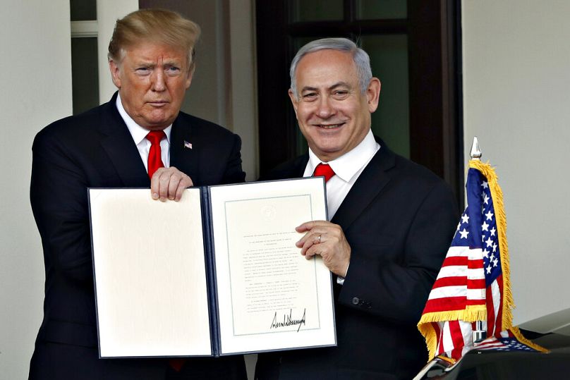الرئيس الأمريكي دونالد ترامب ورئيس الوزراء الإسرائيلي بنيامين نتنياهو يرفعان إعلانًا موقّعًا بعد لقائهما في البيت الأبيض، 25 آذار/ مارس 2019، واشنطن.