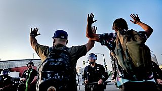 Los Angeles police officers with batons and riot gear attempt to move back protesters in downtown Los Angeles on Monday, June 9, 2025