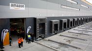 Employees wait for France's President Emmanuel Macron at new Amazon facility, in Longueau, northern France, Tuesday, Oct. 3, 2017