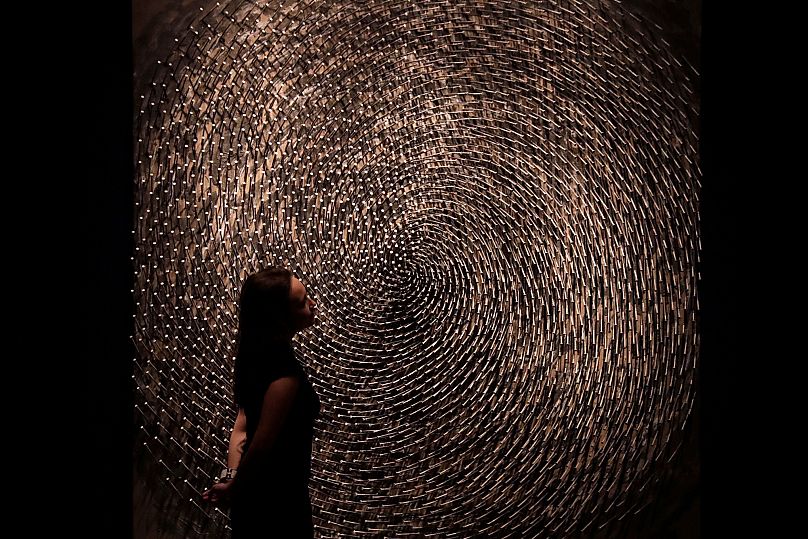 A Christie’s employee poses with Günther Uecker’s Spirale I, Spirale II (Doppelspirale) at the London auction house, 3 March 2017.