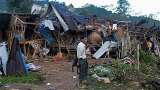 A man looks on at homes destroyed after air and artillery strikes in Mung Lai Hkyet displacement camp in Laiza, 10 October, 2023