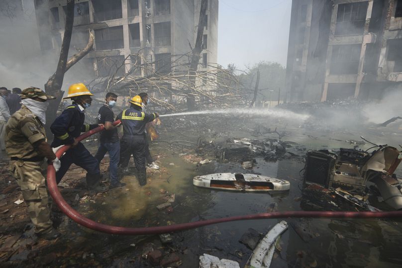 Firefighters work at the site of an airplane that crashed in India's northwestern city of Ahmedabad in Gujarat state, India, Thursday, June 12, 2025.