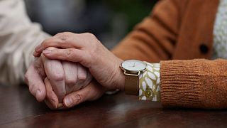 People hold hands.