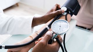 A doctor checks a patient's blood pressure.