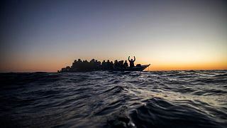 Migrants and refugees wait for assistance on an overcrowded wooden boat in the Mediterranean Sea off the Libyan coast, 12 February, 2021