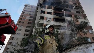 A firefighter calls out his colleagues at the scene of an explosion in a residence compound in northern Tehran, Iran. 13 June 2025.