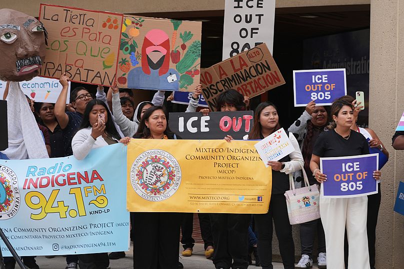 Demonstranten halten Schilder während einer Kundgebung gegen die ICE-Razzien am Donnerstag, 12. Juni 2025, in Ventura, Kalifornien (AP Photo/Damian Dovarganes).