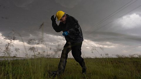 Joey Toniolo ducks from falling hail as he moves back to the hail hunter vehicle during a Project ICECHIP operation, 6 June 2025, in Morton, Texas.