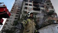 A firefighter calls out his colleagues at the scene of an explosion in a residence compound in northern Tehran, Iran, Friday, June 13, 2025. 