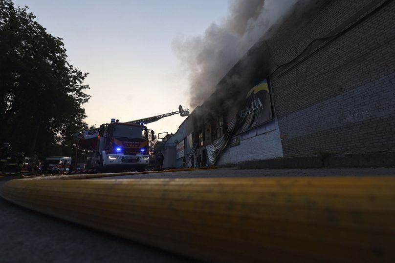 Kurtarma görevlileri, Zaporijya'da Rus insansız hava aracı saldırısı sonucu tahrip olan bir insani yardım deposunda çıkan yangını söndürüyor, 14 Haziran 2025.