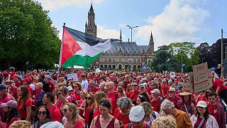 Tens of thousands of red-clad protesters marched past the Peace Palace during a demonstration in The Hague, Netherlands, Sunday, June 15, 2025.